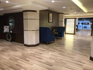 a waiting room with blue chairs and wooden floors at Ajwaa Suites in Jeddah