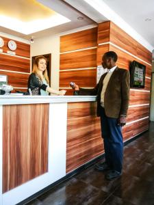 a man and a woman standing at a bar at Salut Hotel in Bishkek