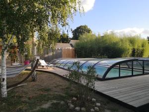 - une piscine installée à côté d'une terrasse en bois dans l'établissement La Cabane Bois des Roses, à Les Rosiers