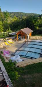 a large swimming pool with a pavilion and a swimming poolvisor at Chambres d'hôtes Le Petit Roche in Arc-et-Senans