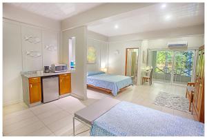 a bedroom with a bed and a kitchen and a room at Hotel Plaza Yara in Manuel Antonio