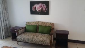 a chair with two green pillows in a room at Vista Bonita Apartments in Mossel Bay