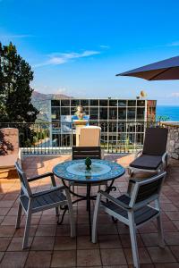 a patio with a table and chairs and a view of the ocean at Villa Maremonti in Taormina
