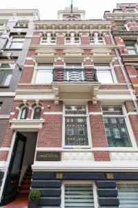 a building with a balcony on the side of it at Amsterdam Canal Hotel in Amsterdam