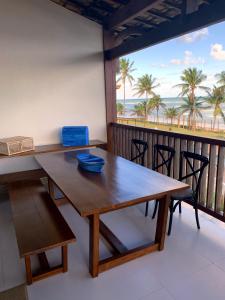 a dining room with a table and a view of the beach at Apartamento beira-mar no Bali Bahia in Itacimirim