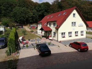una casa con dos coches estacionados frente a ella en Pension Edelstein, en Ostseebad Sellin