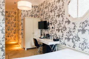 a room with a desk and a wall with wallpaper at Amsterdam Canal Hotel in Amsterdam
