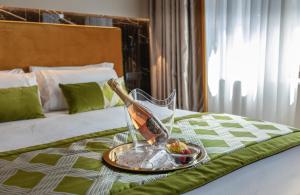 a bottle of champagne on a tray on a bed at NEMAN Maison Experience I Pantheon in Rome