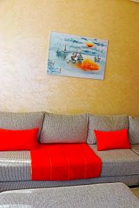 a couch with red pillows in a living room at Appartement Standing Quartier Tour Hassane (près Marina) in Rabat