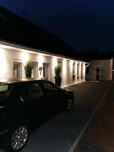 ein Auto, das nachts vor einem Gebäude parkt in der Unterkunft Apartments Margaretenhof in Wilhelmshaven