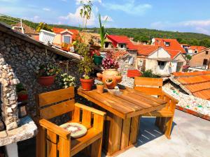 a wooden table and chairs on top of a balcony at Guest House San Nikola in Stari Grad