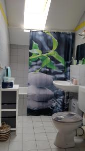 a bathroom with a shower curtain and a toilet at Michaels Wildgatter in Grafenwiesen