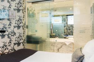 a bedroom with a bed and a glass shower at Amsterdam Canal Hotel in Amsterdam