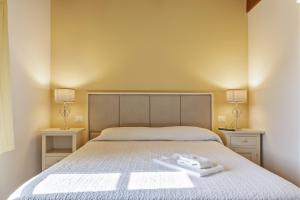 ラストラ・ア・シーニャにあるResidenza Piandaccoliのベッドルーム1室(ランプ2つ、タオル付)