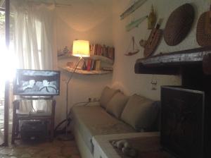 a living room with a couch and a television at Alexandra villas in Gouvia