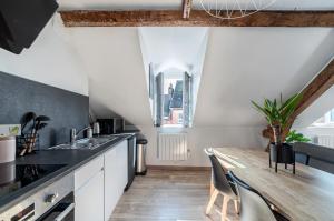 a kitchen with a wooden table and a dining area at Appartement cosy*** Centre historique Dieppe - rue piétonne à 200m de la plage in Dieppe