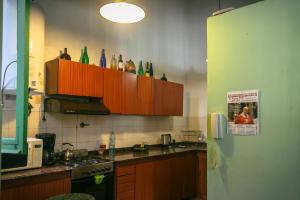 a kitchen with wooden cabinets with bottles on the wall at Experiencia Congreso in Buenos Aires +14 photos