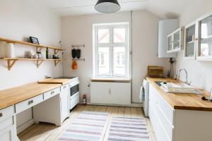 a kitchen with white cabinets and a window at Spacious Private Apartment for Family Holiday in Stege