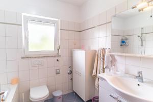 La salle de bains blanche est pourvue d'un évier et d'un réfrigérateur. dans l'établissement Big 4 bedroom apartment with private parking, à Zagreb 19 autres photos