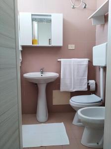 卡薩拉巴特的住宿－La Nassa Salento，粉红色的浴室设有水槽和卫生间