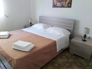 卡薩拉巴特的住宿－La Nassa Salento，一间卧室配有一张大床和两条毛巾