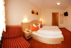 Habitación de hotel con cama y silla en Apart Garni Hax'n Tenne, en Serfaus