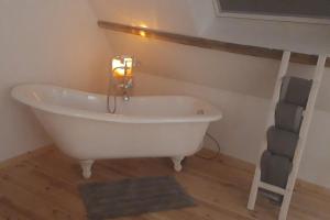 ein Bad mit einer weißen Badewanne in einem Zimmer in der Unterkunft Le nid douillet in Offrethun