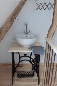 ein Badezimmer mit einem Waschbecken auf einem Tisch im Dachgeschoss in der Unterkunft Le nid douillet in Offrethun