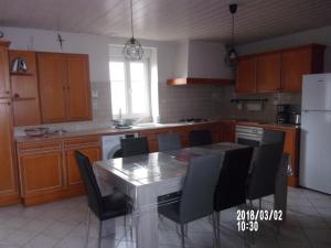 a kitchen with a table and chairs and a refrigerator at La Limouz in Le Boupère