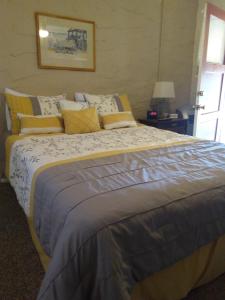 a bedroom with a large bed with yellow and gray pillows at Grand Canyon West Hotel Sheps Miners Inn in Chloride