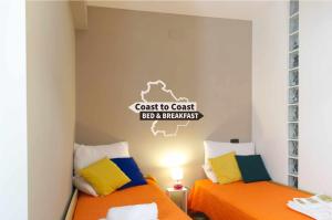 a bedroom with two beds and a sign on the wall at B&B Coast to Coast in Armento