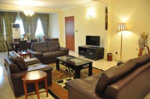 a living room with a couch and a tv at Hôtel Prince De Galles in Douala