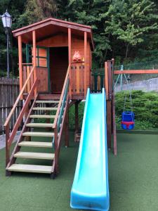 a playground with a slide and a play house at Domek na Jasnej in Muszyna