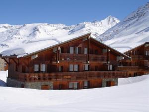 un lodge dans la neige avec des montagnes enneigées dans l'établissement Chalet Le Grand Cap, à Tignes