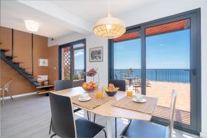 a dining room with a table and a balcony at Seasky Arco in Arco da Calheta