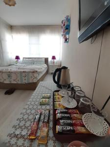 een kamer met een bed en een tafel met veel afstandsbedieningen bij SAYDAM OTEL in Seyhan