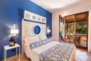 um quarto com uma cama com uma parede azul em Hotel Orsa Maggiore em Vulcano