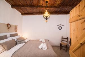 a bedroom with a bed with towels on it at ARADENA TRADITIONAL House 2 in Arádhaina