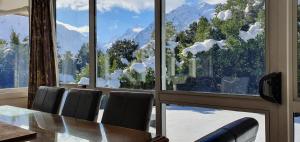 a dining room with a table and a large window at Aoraki Alpine Chalet in Mount Cook Village