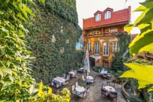 a large ivy covered building with tables and chairs at Boutique Hotel Carpe Diem in Prešov