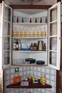 a cabinet filled with bottles and glasses of alcohol at Casa da Rainha in Azambuja