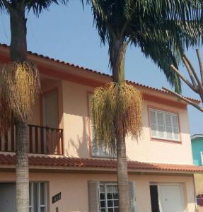 南聖洛倫索的住宿－Apto 02 São Lourenço do Sul，两棵棕榈树在房子前面