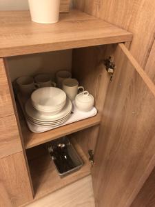 a cabinet with plates and cups on a shelf at Domek na Jasnej in Muszyna