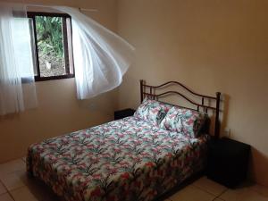 um quarto com uma cama e uma janela em Sítio Iracema em Porto Alegre