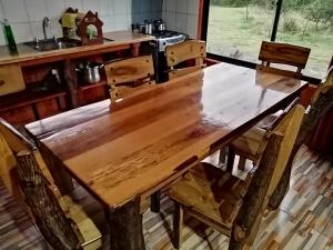 einen Holztisch mit Stühlen in der Küche in der Unterkunft Cabañas El Diuco en Coñaripe 1 in Coñaripe