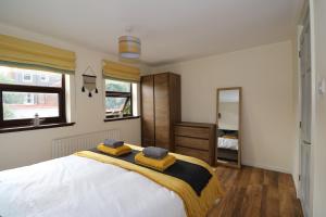 ein Schlafzimmer mit einem großen Bett mit zwei Handtüchern darauf in der Unterkunft Peartree Cottage - Derby in Derby