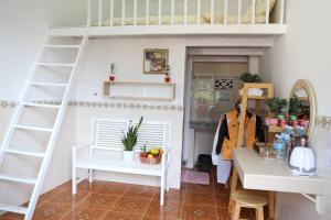 a dollhouse room with a loft bed and a table at Strawberry Hotel Dalat in Da Lat