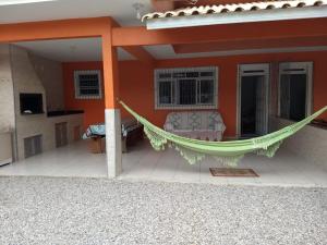 eine Hängematte auf der Veranda eines Hauses in der Unterkunft Casa de Praia in Governador Celso Ramos