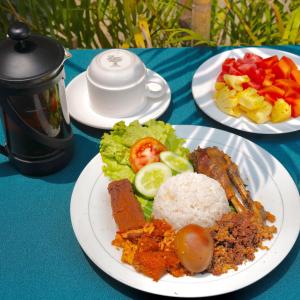 a table with three plates of food on it at Rumah Desa Homestay in Prambanan