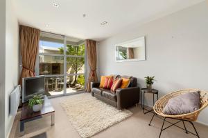 a living room with a couch and a tv at Horoeka on Hallenstein in Queenstown